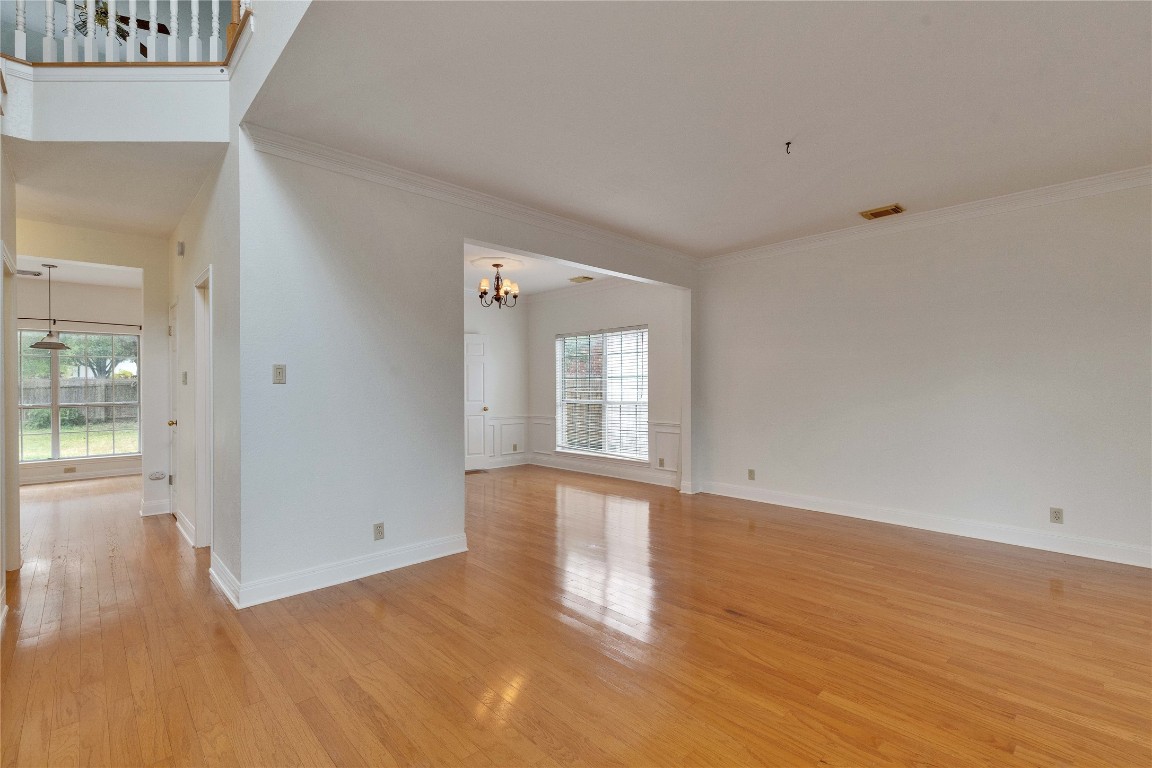 5407 Merrywing Circle Austin, TX 78730 - Photo 7 of 36 Empty room featuring light wood-style floors, crown molding, and a chandelier