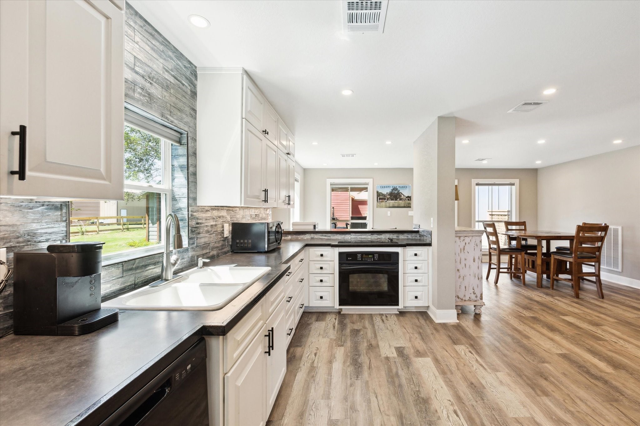 6063 Fm 1094 Sealy, TX 77474 - Photo 24 of 47 a kitchen with stainless steel appliances granite countertop a stove top oven a sink dishwasher a dining table and chairs with wooden floor