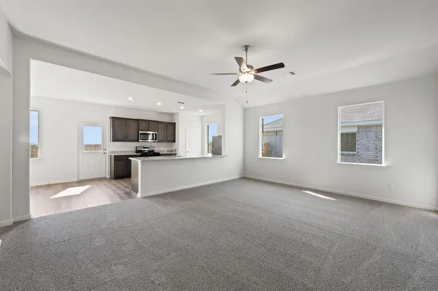 a view of a kitchen with refrigerator and windows