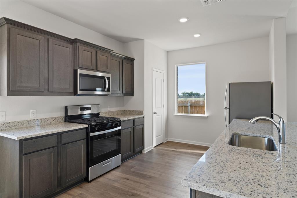 13413 Hang Fire Lane Cresson, TX 76035 - Photo 4 of 8 a kitchen with a sink stove and microwave