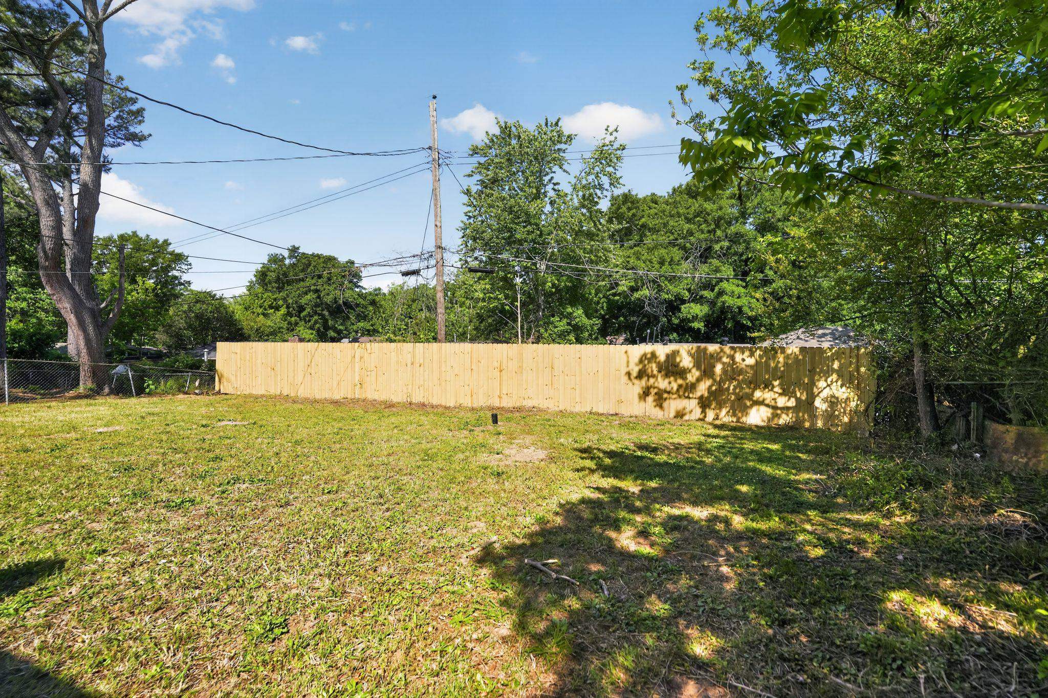 3445 Powers Road Memphis, TN 38128 - Photo 11 of 35 Expansive yard space featuring a newly installed privacy fence, mature trees, and a chain-link fence