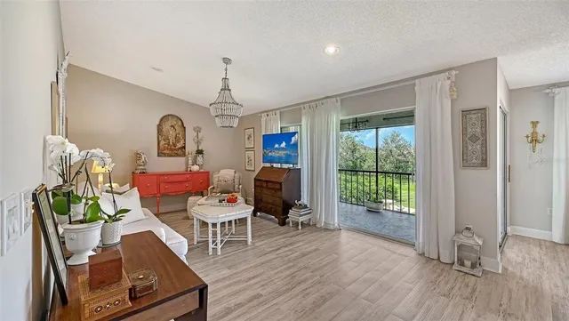 a living room with furniture floor to ceiling window and wooden floor