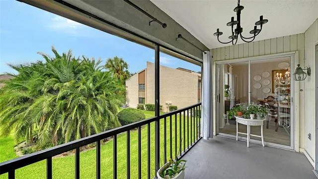 a view of a porch with chairs and potted plants
