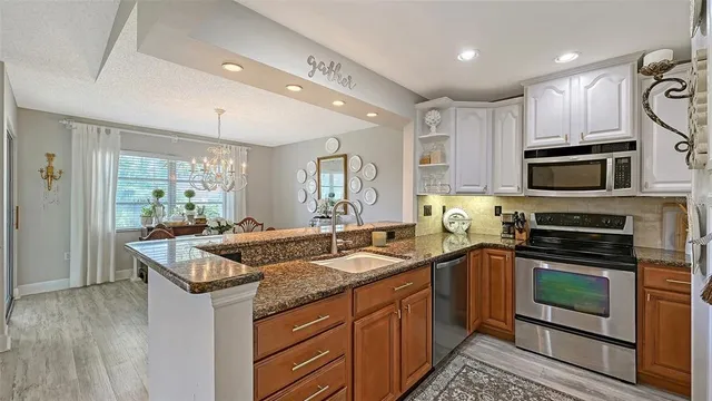a kitchen with stainless steel appliances granite countertop a sink and a stove