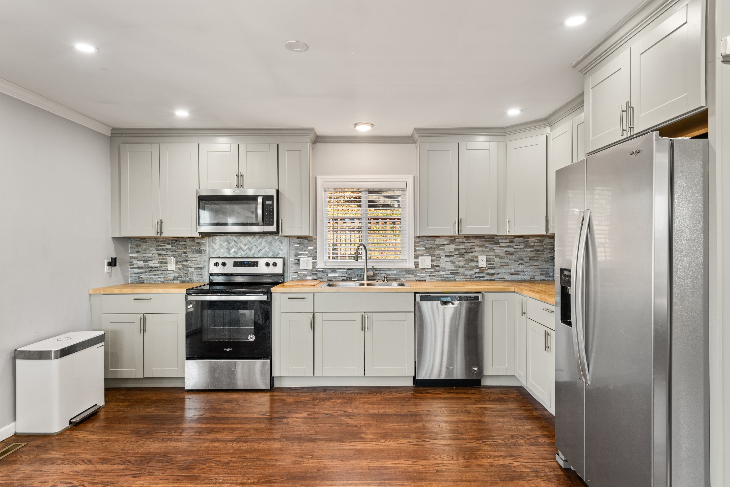 3 Highland Avenue Ansonia, CT 06401 - Photo 17 of 38 a kitchen with stainless steel appliances granite countertop a refrigerator a stove top oven a sink and dishwasher with wooden floor