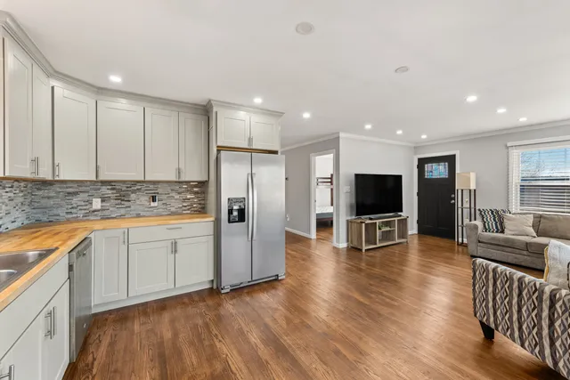 a view of kitchen with stainless steel appliances granite countertop refrigerator oven stove and a wooden floors
