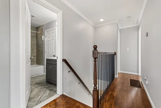 a view of a hallway with wooden floor and staircase