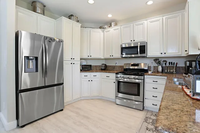 a kitchen with cabinets stainless steel appliances and a counter space