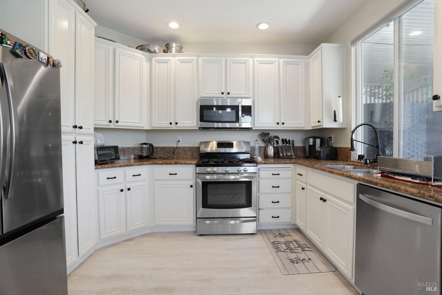 234 Cedar Ridge Drive Rio Vista, CA 94571 - Photo 14 of 33 a kitchen with stainless steel appliances granite countertop a refrigerator sink and white cabinets