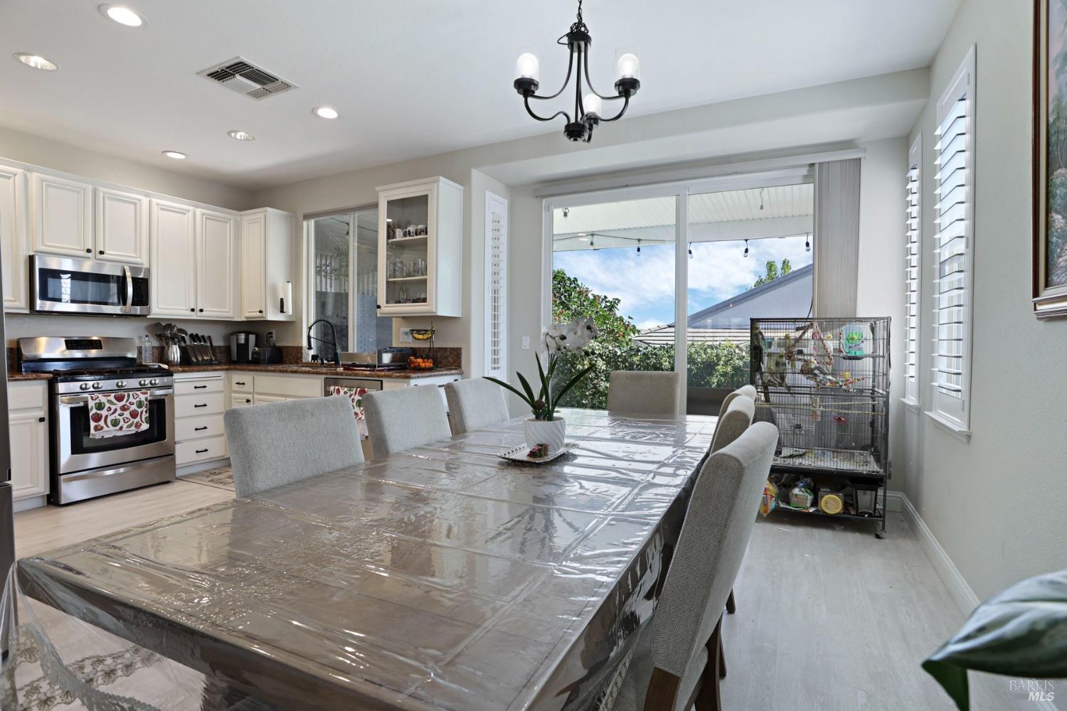 234 Cedar Ridge Drive Rio Vista, CA 94571 - Photo 17 of 33 a kitchen with stainless steel appliances granite countertop a stove top oven a sink a dining table and chairs with wooden floor