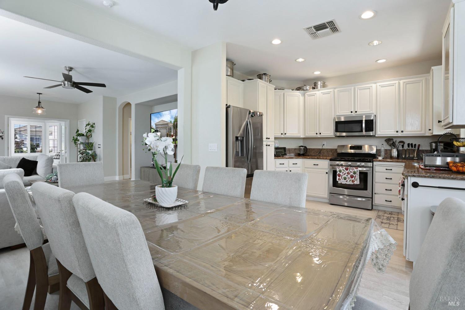 234 Cedar Ridge Drive Rio Vista, CA 94571 - Photo 18 of 33 a kitchen with stainless steel appliances granite countertop a refrigerator a stove top oven a sink a dining table and chairs with wooden floor
