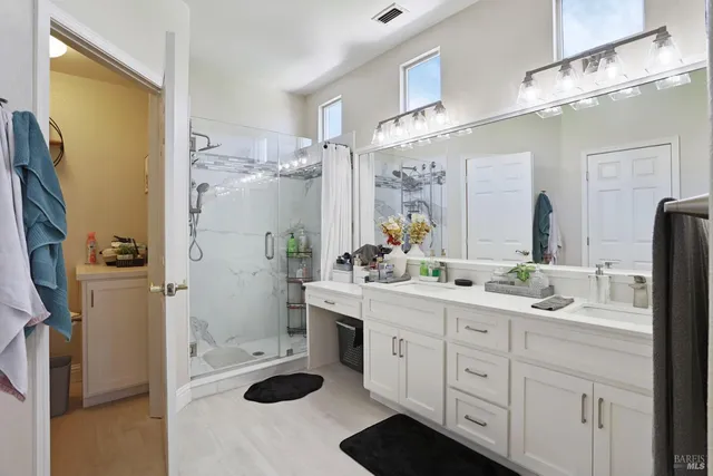 a spacious bathroom with a sink a shower and a mirror