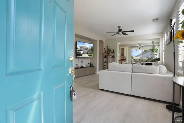 a living room with furniture a flat screen tv and a window