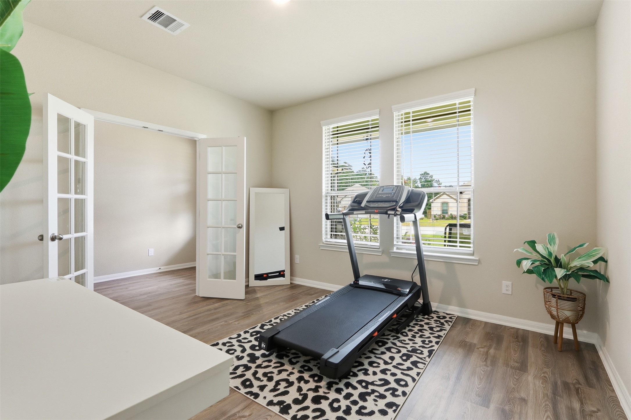 6310 Fawn Path Drive Conroe, TX 77303 - Photo 7 of 41 Flexible home office or study featuring elegant French doors, wood flooring, and large windows that fill the space with natural light.