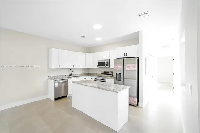 a kitchen with stainless steel appliances a refrigerator sink and stove