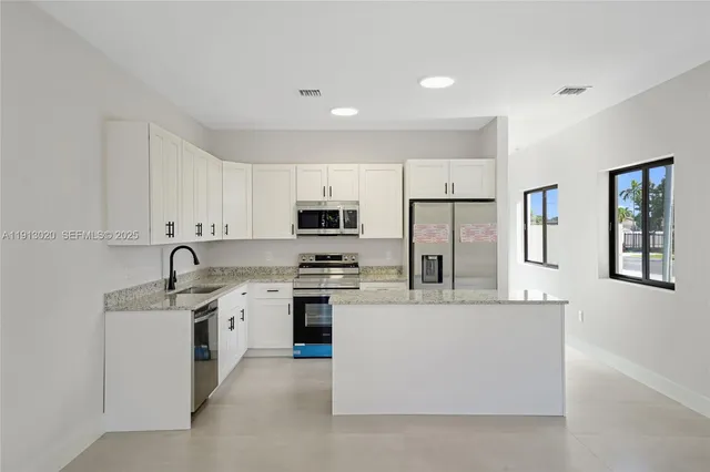 a kitchen with stainless steel appliances a refrigerator stove microwave and sink