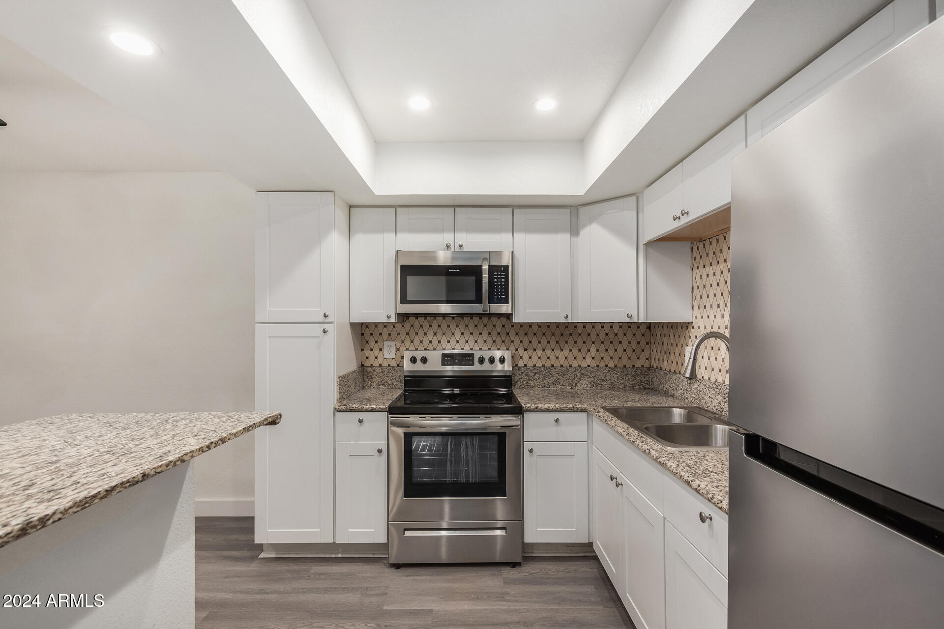 18202 Cave Creek Road, Unit 141 Phoenix, AZ 85032 - Photo 6 of 13 a kitchen with stainless steel appliances granite countertop a stove and a sink