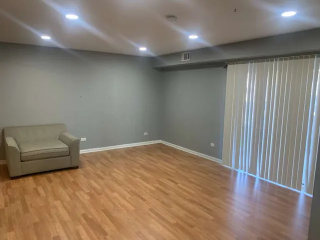 an empty room with a wooden floor and a window