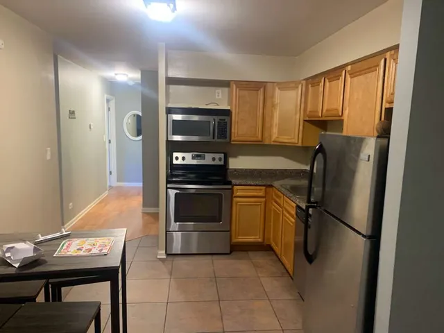 a kitchen with granite countertop stainless steel appliances and a refrigerator