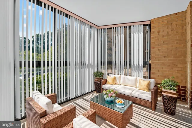 a living room with furniture and a floor to ceiling window