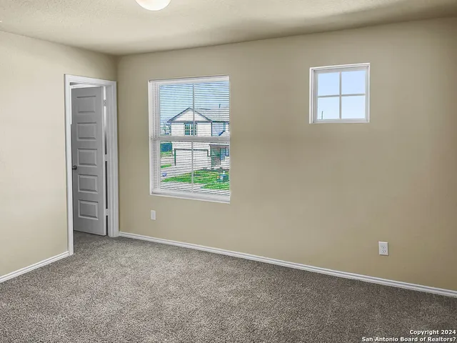 an empty room with windows and closet