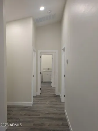 a view of a hallway with wooden floor windows and a livingroom