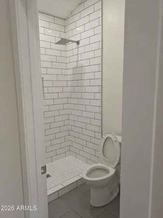 a white toilet sitting next to a white wall
