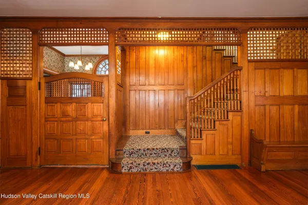 a view of a hallway with wooden floor and staircase