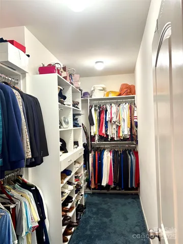 a view of walk in closet with clothes and shoes