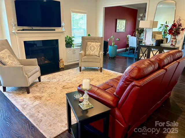 a living room with furniture a fireplace and a flat screen tv