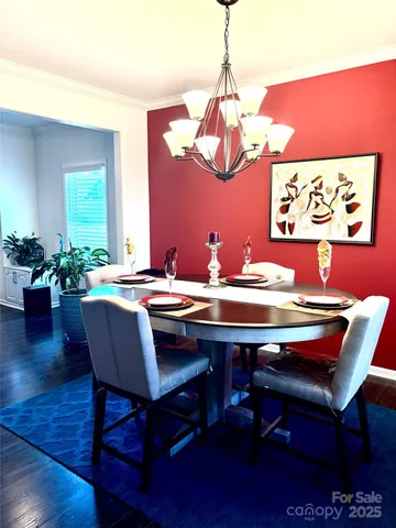 a view of a dining room with furniture wooden floor and chandelier