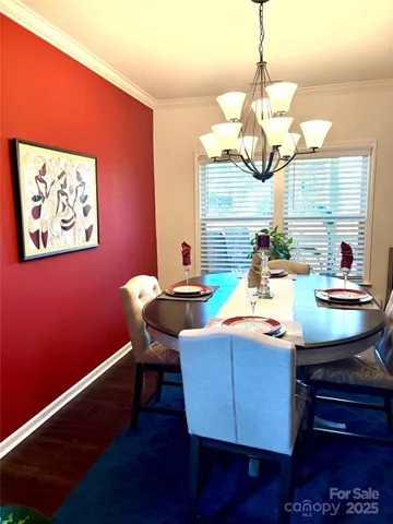 a view of a dining room with furniture wooden floor and chandelier