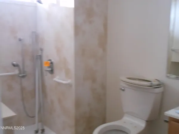 a white toilet sitting next to a shower