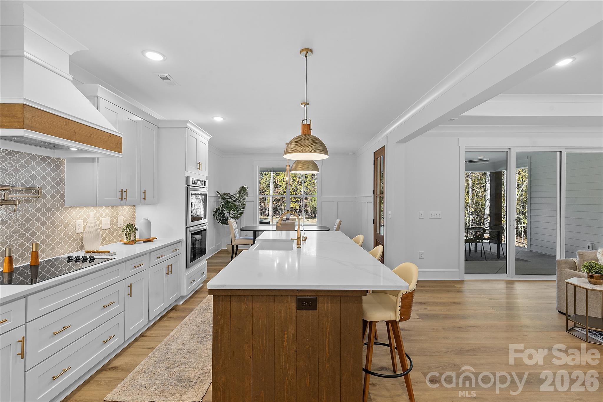 9729 Flowes Store Road Midland, NC 28107 - Photo 16 of 29 a kitchen with stainless steel appliances granite countertop a stove a sink dishwasher and white cabinets with wooden floor