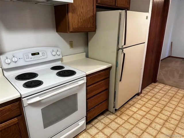a white refrigerator freezer and a stove sitting inside of a kitchen