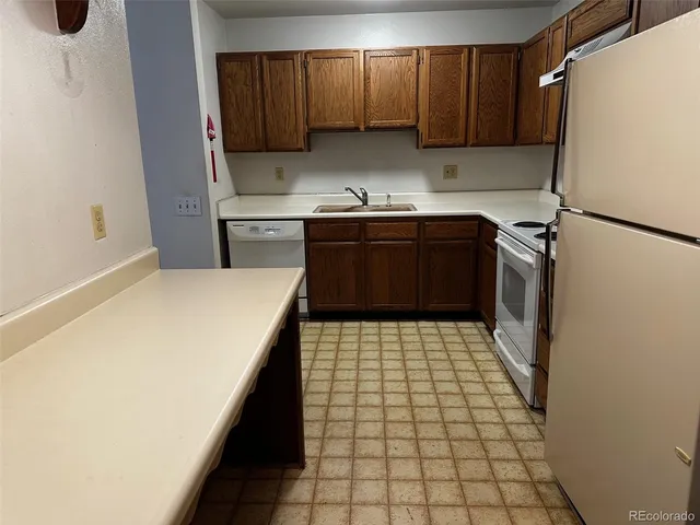 a kitchen with a refrigerator sink and cabinets