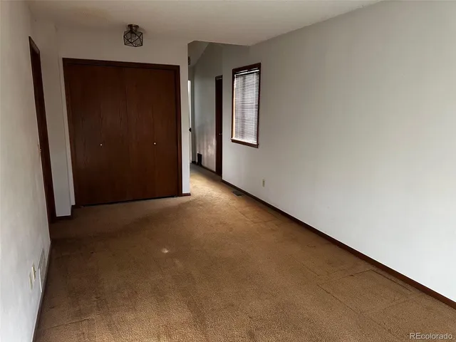 an empty room with windows and closet