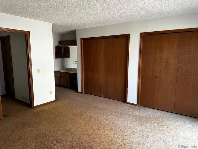 a view of an empty room with a kitchen