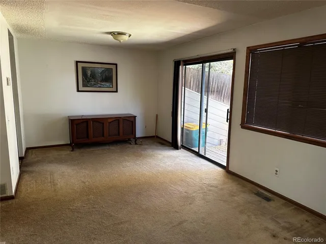a view of a livingroom with glass door and furniture