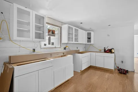 a view of kitchen with sink cabinets and window