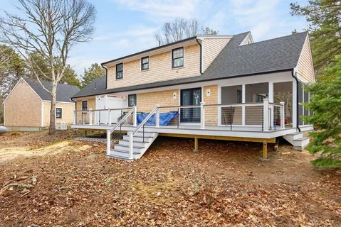 a view of a house with backyard and chairs