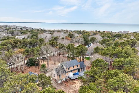 an aerial view of a house with a yard and wooden fence