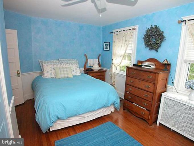 1100 Overbrook Road Baltimore, MD 21239 - Photo 13 of 23 a bed sitting in a bedroom next to a window