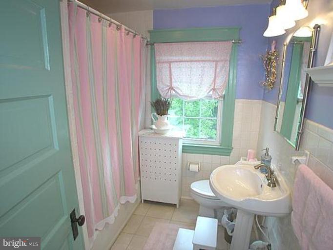 1100 Overbrook Road Baltimore, MD 21239 - Photo 14 of 23 a bathroom with a sink a mirror and a toilet