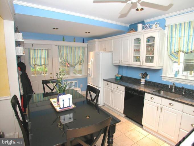 1100 Overbrook Road Baltimore, MD 21239 - Photo 6 of 23 a open kitchen with stainless steel appliances granite countertop a stove a sink a dining table and chairs