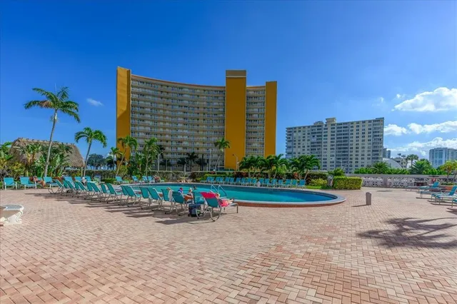 a view of a patio with a table and chairs under an umbrella with wooden fence