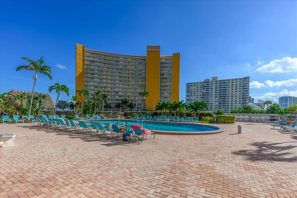 405 North Ocean Boulevard, Unit 611 Pompano Beach, FL 33062 - Photo 13 of 39 a front view of a building with a garden and plants