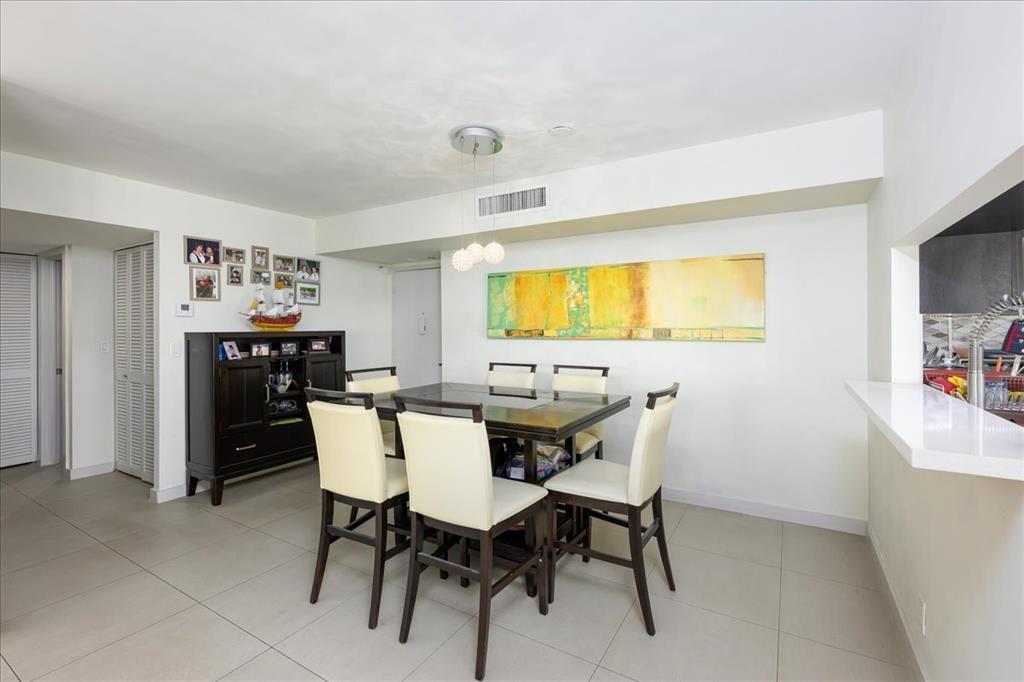 405 North Ocean Boulevard, Unit 611 Pompano Beach, FL 33062 - Photo 7 of 39 a view of a dining room with furniture and a chandelier