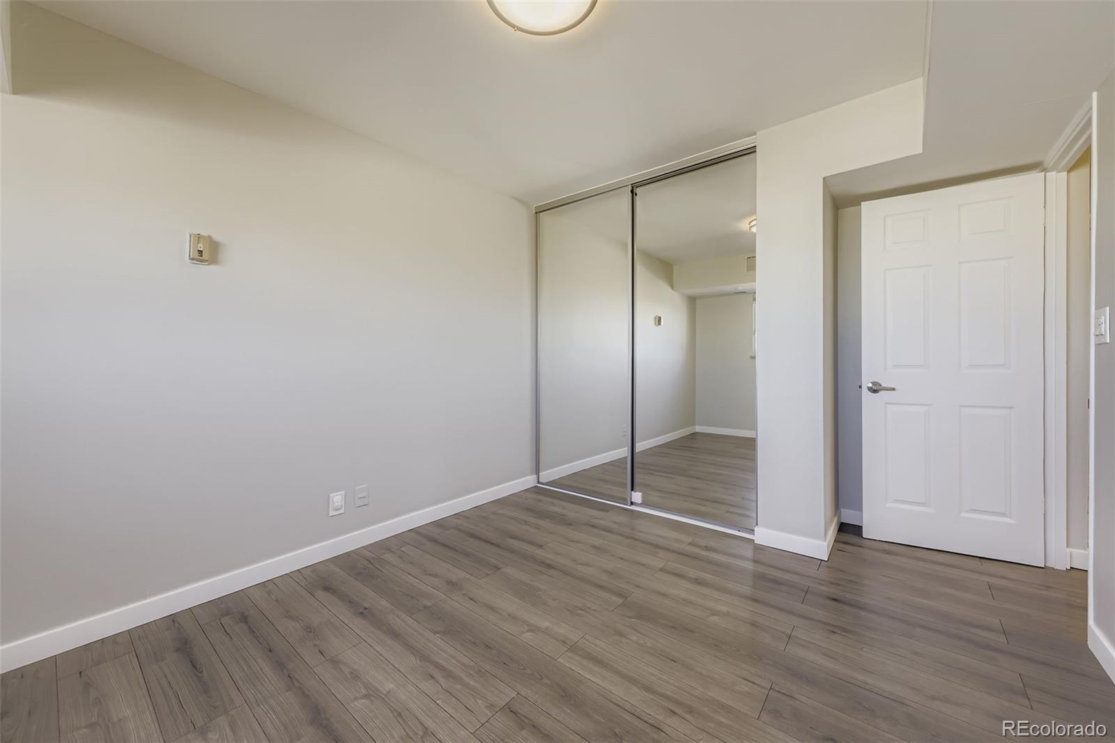 1121 Albion Street, Unit 709 Denver, CO 80220 - Photo 15 of 24 an empty room with wooden floor and mirror