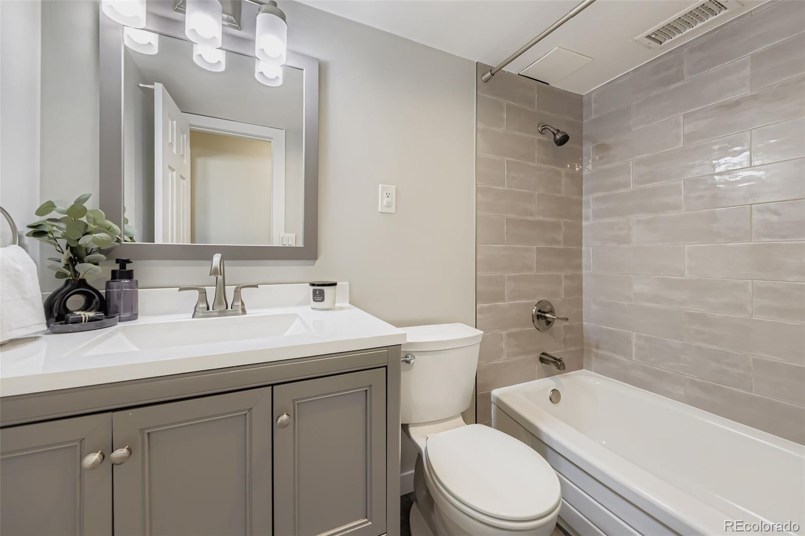 1121 Albion Street, Unit 709 Denver, CO 80220 - Photo 16 of 24 a bathroom with a sink a toilet a mirror a vanity and bathtub